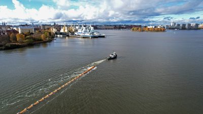 Moottorivene hinaa jätevesiputkea Kruunuvuorenrannasta Siltavuorenrantaan.